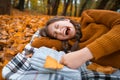 a young teenage girl lies in a clearing by the river bank in the autumn forest, wants to sleep and yawns, enjoying the beautiful Royalty Free Stock Photo