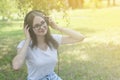 Young teenage girl listening music with headphones and smart phone in the park, summer portrait Royalty Free Stock Photo