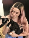 Young teenage girl with long hair holding a pet black cat Royalty Free Stock Photo