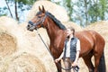 Young teenage owner girl leading beautiful chestnut horse. Royalty Free Stock Photo