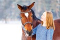 Young teenage girl with bay horse in winter park Royalty Free Stock Photo