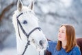 Young teenage girl with white horse in winter park Royalty Free Stock Photo