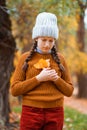 a young teenage girl posing in an autumn forest, she is unhappy and has a sad mood, standing by a tree, beautiful nature and Royalty Free Stock Photo