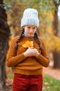 a young teenage girl posing in an autumn forest, she is unhappy and has a sad mood, standing by a tree, beautiful nature and Royalty Free Stock Photo