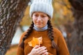 a young teenage girl posing in an autumn forest, she is unhappy and has a sad mood, standing by a tree on the riverbank, beautiful Royalty Free Stock Photo