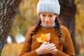 a young teenage girl posing in an autumn forest, she is unhappy and has a sad mood, standing by a tree on the riverbank, beautiful Royalty Free Stock Photo