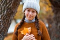 a young teenage girl posing in an autumn forest, she is unhappy and has a sad mood, standing by a tree on the riverbank, beautiful Royalty Free Stock Photo