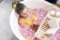 Girl reading book while relaxing in spa bath with flowers Royalty Free Stock Photo