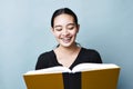 Young Teenage Girl Reads from Text Book and Smiles Happy Lauging Expression