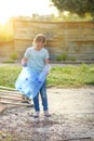 Kid cleaning in park.Volunteer child with a garbage bag cleaning up litter, putting plastic bottle in recycling bag. Royalty Free Stock Photo