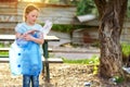 Kid cleaning in park.Volunteer child with a garbage bag cleaning up litter, putting plastic bottle in recycling bag. Royalty Free Stock Photo