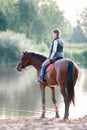 Young teenage girl riding horseback to river at early morning Royalty Free Stock Photo