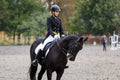 Young teenage girl riding raven horse on dressage equestrian event Royalty Free Stock Photo