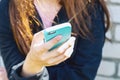 A young teenage girl is sitting outside on the street and holding a cell phone in her hands. Communication by Mobile phone. Love f