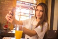 Young teenage girl taking a selfie on mobile phone at restaurant. Royalty Free Stock Photo