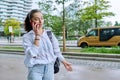 Young teenage girl talking on phone, outdoor on street of modern city Royalty Free Stock Photo