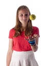 Young teenage girl throwing a tennis ball in the air