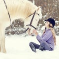 Young teenage girl with white horse in winter park Royalty Free Stock Photo