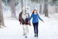 Young teenage girl with white horse in winter park Royalty Free Stock Photo