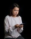 Young teenage girl holding cell phone