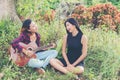 Young teenage looking at her female friend while playing guitar,Relaxing time enjoyment.