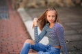 Young teenage poses for photo. blonde girl in jeans and blouse. play with hair Royalty Free Stock Photo