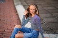 Young teenage poses for photo. blonde girl in jeans and blouse. play with hair Royalty Free Stock Photo