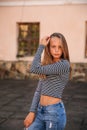 Young teenage poses to photographer. blonde girl in jeans and blouse Royalty Free Stock Photo