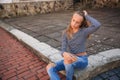 Young teenage poses to photographer. blonde girl in jeans and blouse Royalty Free Stock Photo