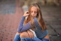 Young teenage poses to photographer. blonde girl in jeans and blouse Royalty Free Stock Photo