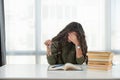 Young teenage school or college university student girl with curly hair have a headache and is tired after hours of reading books Royalty Free Stock Photo