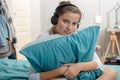 young teenage sitting on bed in bedroom listen to music with headphones