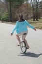 Young Teenage Woman Riding Down A Residential Neighborhood Street Balancing on a Unicycle Royalty Free Stock Photo