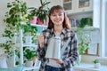 Young teenage woman watering pots with plants from watering can Royalty Free Stock Photo