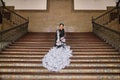 Young teenage woman in white dance suit with black polka dots, black shawl and green carnations in her hair doing flamenco poses Royalty Free Stock Photo