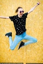 Young teenaged girl jumping in front of fence from wooden mdf pa Royalty Free Stock Photo