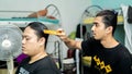 Young teenager applying a hair cream product to straighten the curly hair of his friend