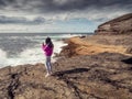 Young teenager blogger filming stunning nature scene on her smart phone. Ireland, Kilkee area. travel, tourism and sightseeing