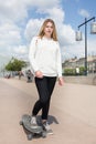 Young teenager blond girl with longboard skate board