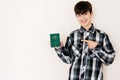 Young teenager boy holding Vatican City passport looking positive and happy standing and smiling with a confident smile against