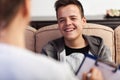 Young teenager boy at counseling not taking it seriously Royalty Free Stock Photo