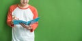 Young teenager boy writing on blue notebook leaning at green wall in school campus,Leave copy space for adding content of design Royalty Free Stock Photo