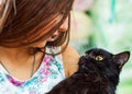 Young teenager brunette girl holding in her arms black cat. Royalty Free Stock Photo