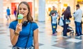 Young teenager brunette girl with long hair eating tasty cone ice cream in shopping mall Royalty Free Stock Photo