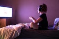 Young teenager gamer with headset playing video game at home in the dark room using game console controller watching at LED TV. Ga