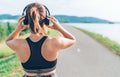 Young teenager girl adjusting  wireless headphones before starting jogging and listening to music Royalty Free Stock Photo
