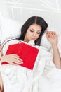 Young teenager girl fell asleep on the bed after reading a book Royalty Free Stock Photo