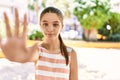 Young teenager girl outdoors on a sunny day with open hand doing stop sign with serious and confident expression, defense gesture Royalty Free Stock Photo