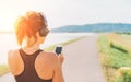 Young teenager girl starting jogging and listening to music using smartphone and wireless headphones. Active sport life concept