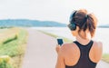 Young teenager girl starting jogging and listening to music using smartphone and wireless headphones. Active sport life concept Royalty Free Stock Photo